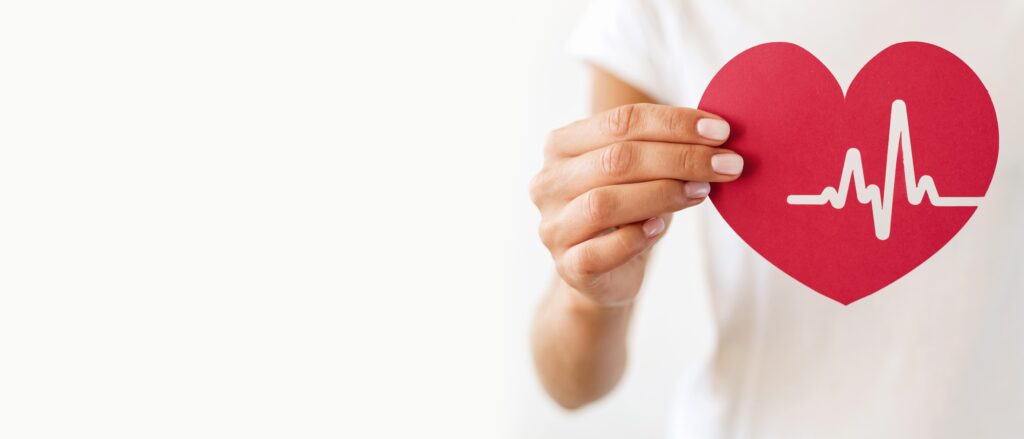 front view woman holding paper heart with heartbeat